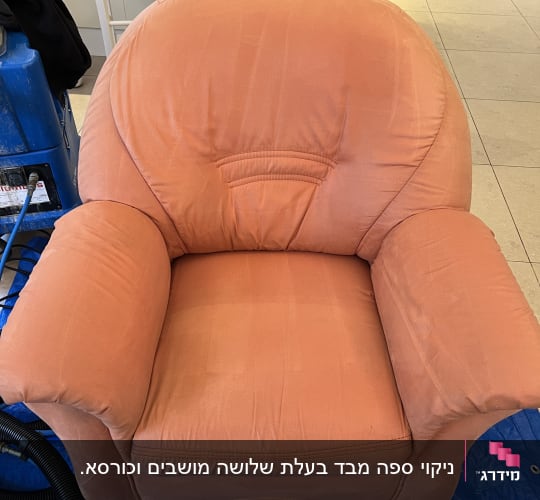כורסה כתומה עם מכונת ניקוי בצד